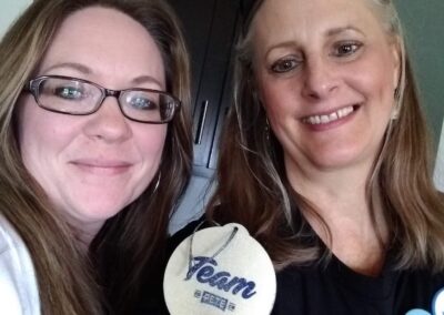 Two women holding a "Team Pete" Christmas ornament